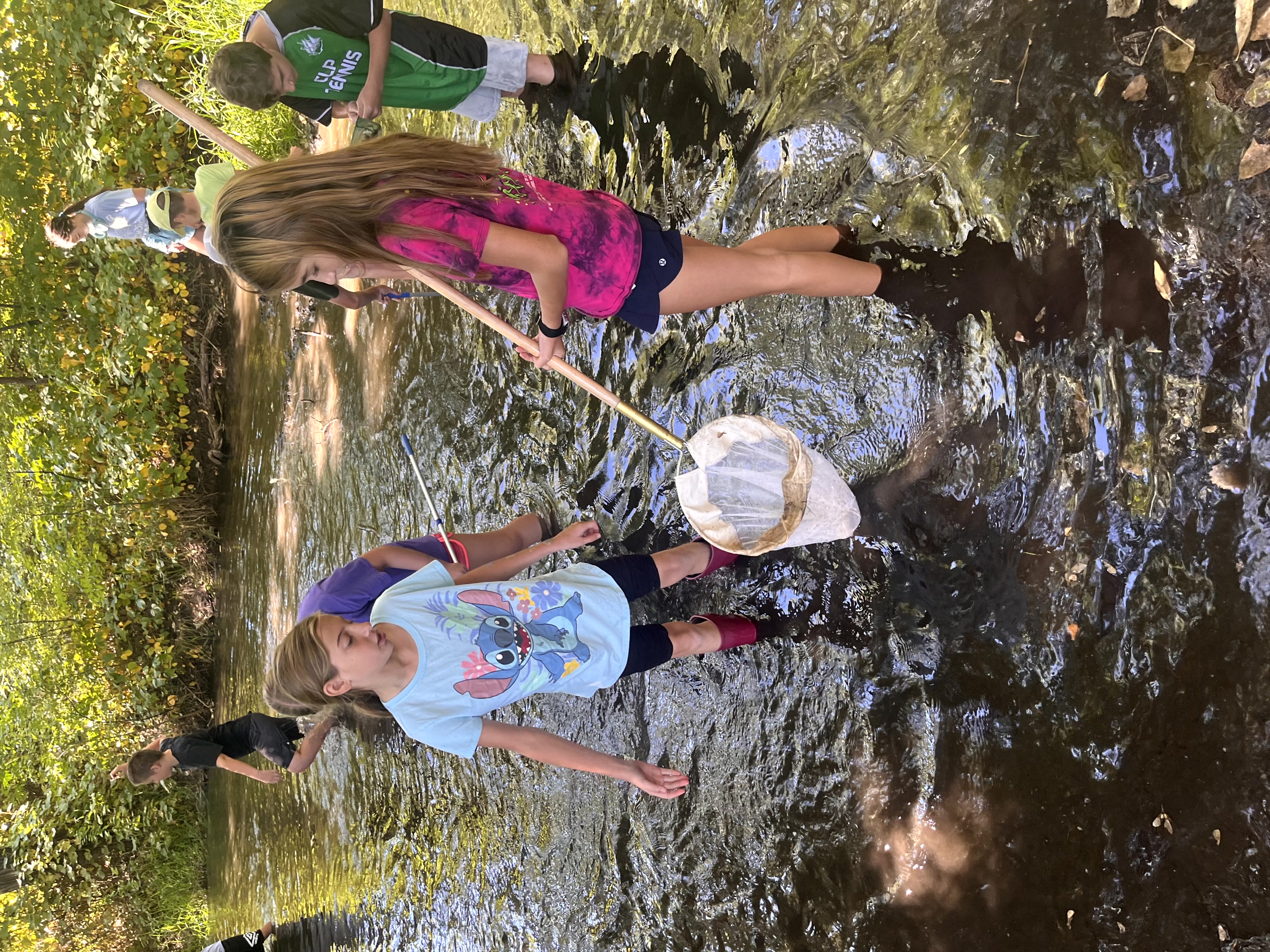 Group of students standing in Poudre River testing water