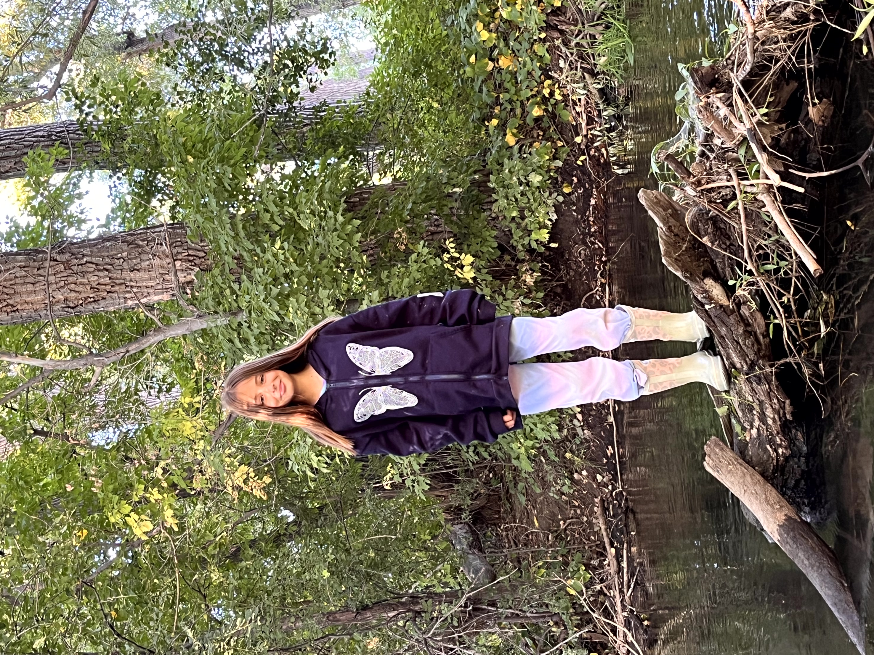 Student standing on branches in the Poudre River