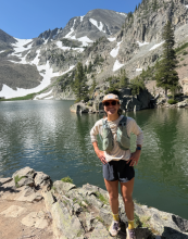 woman stands in front of a mountain